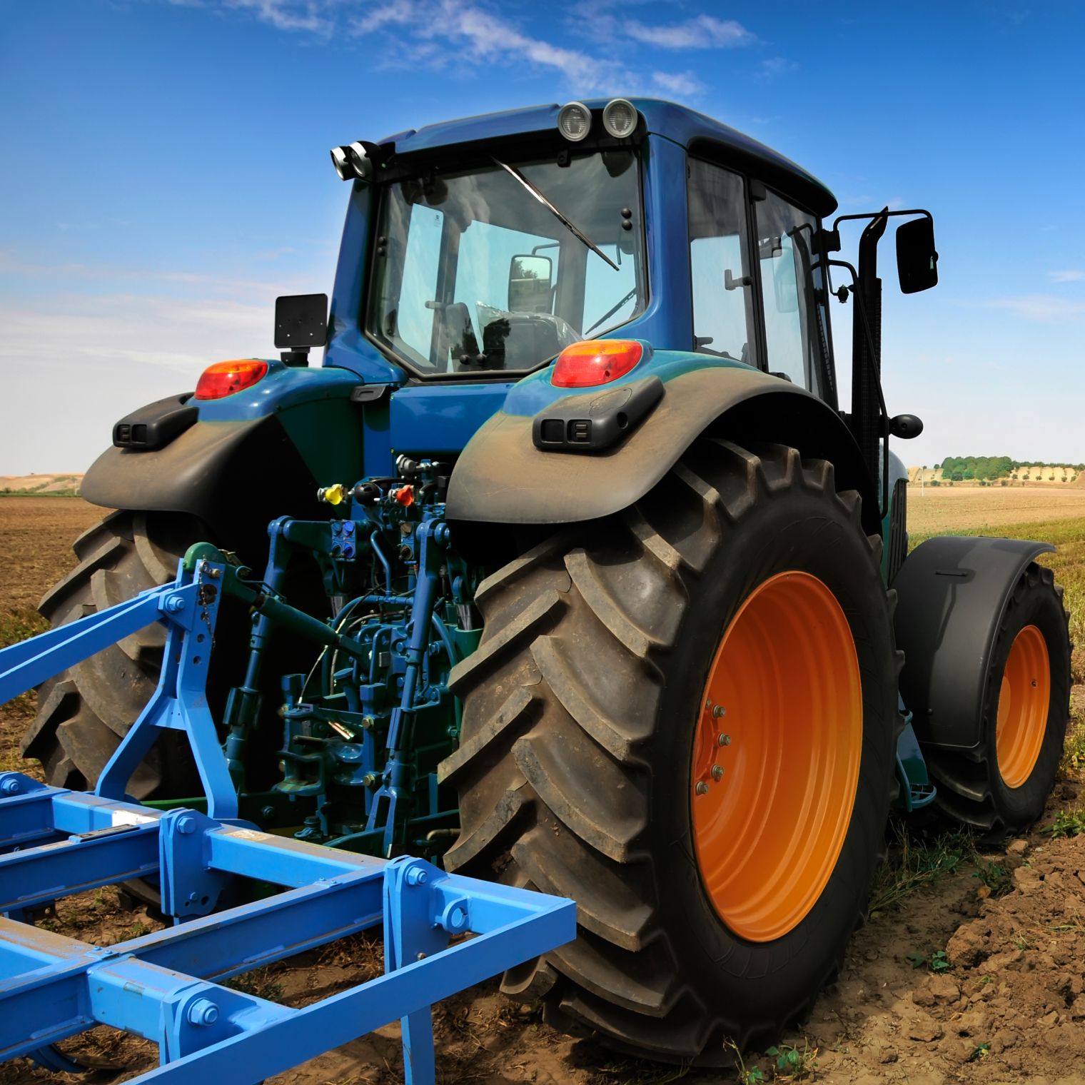 Blaue Landmaschinen beim abfahren des Feldes